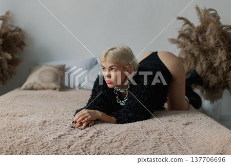 Beautiful woman posing for photographer on bed in Beautiful woman posing for photographer on bed in 137706696