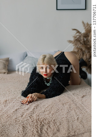 Beautiful woman posing for photographer on bed in Beautiful woman posing for photographer on bed in 137706711