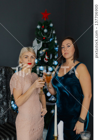 Two women celebrate Christmas by the New Year tree Two women celebrate Christmas by the New Year tree 137706900