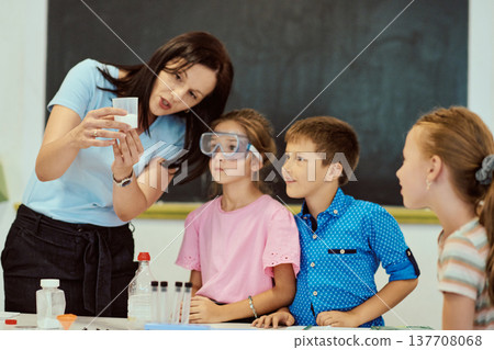 Teacher conducting a hands-on science experiment with attentive elementary students in classroom 137708068