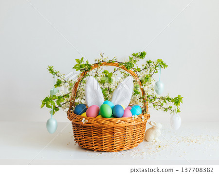 Easter composition with colorful painted eggs in a flower basket on white background. Happy Easter time. 137708382