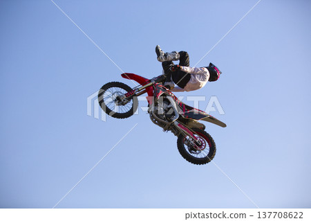 Fearless motocross rider flying above dirt ramp in Almaty 137708622