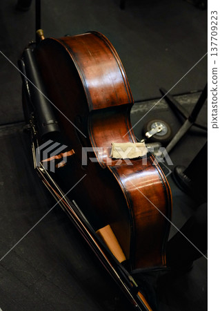 Wooden cello resting backstage in dim concert hall setting Wooden cello resting backstage in dim concert hall setting 137709223