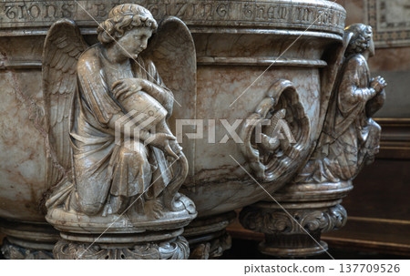 Masterfully carved in marble, this baptismal font from St. Mary Abbots, Kensington, radiates reverence and beauty. It features graceful figures in high relief, such as a kneeling angel holding a Masterfully carved in marble, this baptismal font from St. Mary Abbots, Kensington, radiates reverence and beauty. It features graceful figures in high relief, such as a kneeling angel holding a 137709526