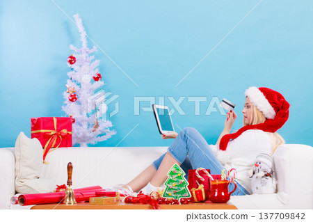 Woman buying christmas gifts online Woman buying christmas gifts online 137709842