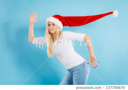 Woman wearing windblown santa hat 137709870