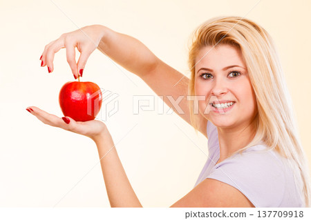Happy woman holding delicious red apple Happy woman holding delicious red apple 137709918