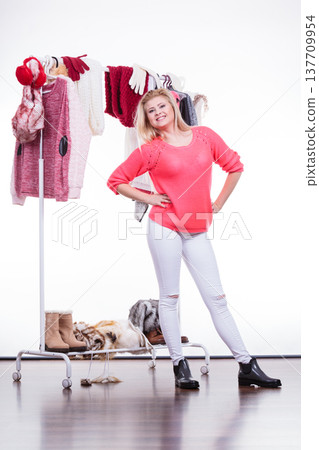 Woman in home closet choosing clothing, indecision 137709954