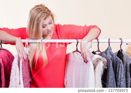 Woman in winter wardrobe deciding what wear 137709973
