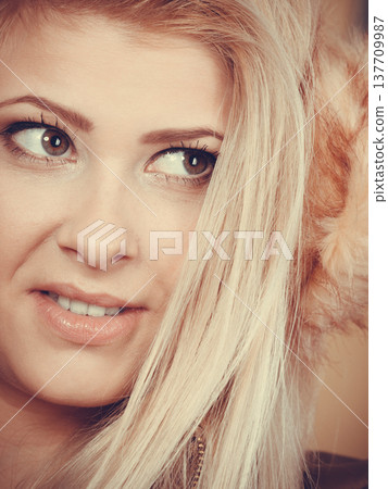 Blonde woman in winter earmuffs and jacket. 137709987