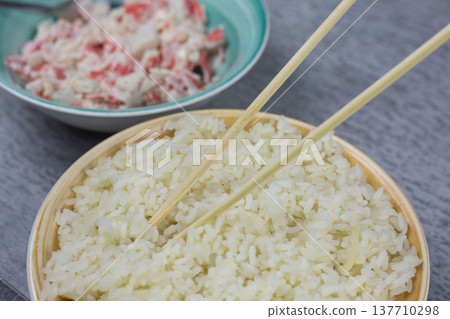 Composition balances bowls of rice and crab mixture side by side. Perfect pairing of staple grain and savory filling for homemade sushi. Culinary harmony in ingredients Composition balances bowls of rice and crab mixture side by side. Perfect pairing of staple grain and savory filling for homemade sushi. Culinary harmony in ingredients 137710298
