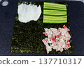 Balanced portions of cream cheese, cucumber, and crab on nori quarters. Each ingredient perfectly proportioned for harmonious bite. Visual guide to building well balanced sushi sandwich 137710317