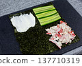 Nori sheet transformed into base for global fusion flavors. Cream cheese, cucumber, and crab mixture arranged in quarters. Creative culinary experiment blending Asian and Western ingredients 137710319