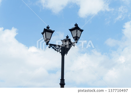 Vintage streetlamp with three lanterns against blue sky Vintage streetlamp with three lanterns against blue sky 137710497