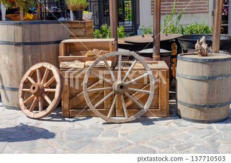 A wooden wheel is sitting on top of a wooden crate 137710503