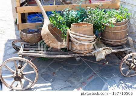 A wooden cart with a large pot and a wooden spoon on top A wooden cart with a large pot and a wooden spoon on top 137710506