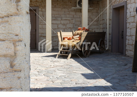 A wooden wagon is sitting in front of a building A wooden wagon is sitting in front of a building 137710507