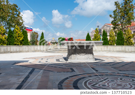 Stone monument sits atop patterned pavement Stone monument sits atop patterned pavement 137710523