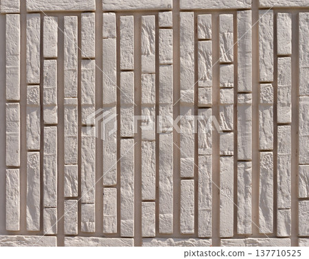 A wall made of light brown brick. 137710525