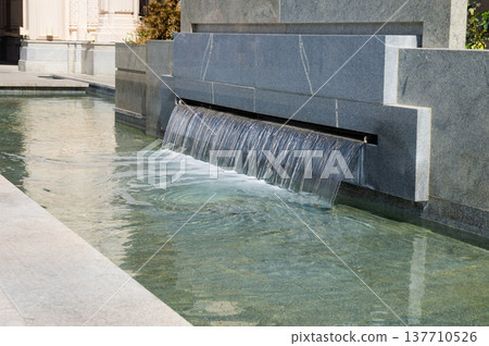 A large water fountain with a clear stream of water A large water fountain with a clear stream of water 137710526