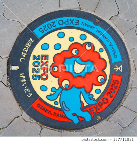 Osaka, Japan - Sep 21 2024, close up view of the manhole cover with a colourful image of the red and blue mascot expo 2025, Osaka, Japan Osaka, Japan - Sep 21 2024, close up view of the manhole cover with a colourful image of the red and blue mascot expo 2025, Osaka, Japan 137711851