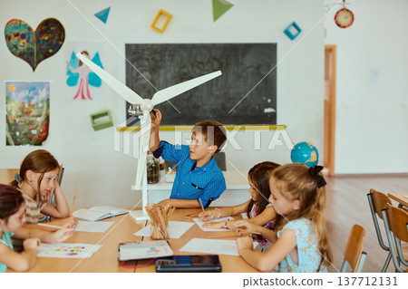 Children building a wind turbine model in a classroom during a hands-on science lesson about renewable energy and teamwork 137712131