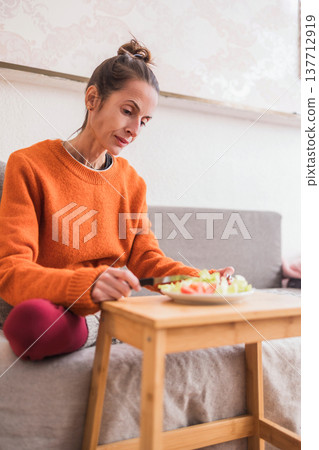Woman struggling with eating disorder eating healthy meal 137712919