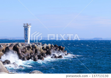 白色海浪拍打著大磯港的防波堤和燈塔。 白色海浪拍打著大磯港的防波堤和燈塔。 137713130