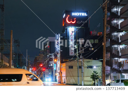 Osaka, Japan - Sep 22 2024, panoramic view of the street with tall buildings and a hotel with a glowing sign in the background, at night, without people, Osaka, Japan Osaka, Japan - Sep 22 2024, panoramic view of the street with tall buildings and a hotel with a glowing sign in the background, at night, without people, Osaka, Japan 137713409