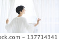 一位年輕女子過著她的日常生活：她每天早晨的例行公事是拉開窗簾。 137714341