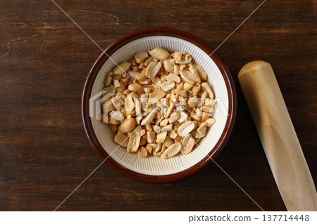 A table background viewed from directly above, with crushed peanuts in a mortar. A table background viewed from directly above, with crushed peanuts in a mortar. 137714448