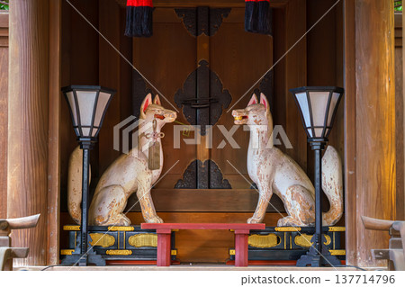 Kyoto, Japan - Sep 23 2024, A close-up view of the Shinto wooden shrine decorated with two statues of white kitsune foxes, servants of God Inari and two lanterns, Fushimi Inari Temple, Kyoto, Japan 137714796