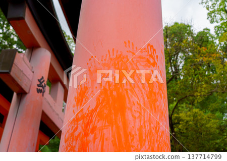 Kyoto, Japan - Sep 23 2024, Close-up view of the dusty column of the giant Torii gate with a lot of handprints, with a park in the background, at daytime, Kyoto, Japan Kyoto, Japan - Sep 23 2024, Close-up view of the dusty column of the giant Torii gate with a lot of handprints, with a park in the background, at daytime, Kyoto, Japan 137714799