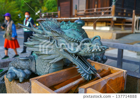 Kyoto, Japan - Sep 23 2024, Close-up view of the head of a bronze statue of a Chinese dragon, at entrance of Temple of Pure Water, Kiyomizu-dera Temple, with people in the background, Kyoto, Japan Kyoto, Japan - Sep 23 2024, Close-up view of the head of a bronze statue of a Chinese dragon, at entrance of Temple of Pure Water, Kiyomizu-dera Temple, with people in the background, Kyoto, Japan 137714888