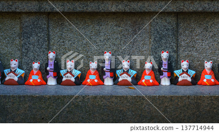 Kyoto, Japan - Sep 23 2024, A close-up view of the many small figures of white kitsune foxes dressed in traditional Japanese costumes at the Fushimi Inari Temple, at daytime, Kyoto, Japan 137714944