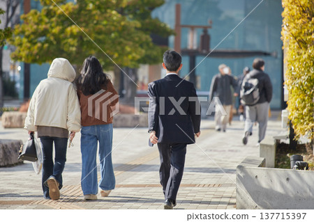 冬日里,一位年輕的女遊客和一位中年商人走在名古屋市中心。 冬日里,一位年輕的女遊客和一位中年商人走在名古屋市中心。 137715397