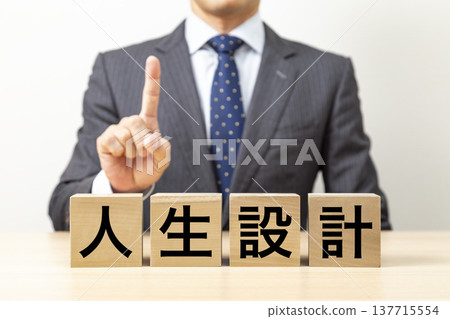 一塊寫著「人生規劃」的磚塊和一個商人 一塊寫著「人生規劃」的磚塊和一個商人 137715554