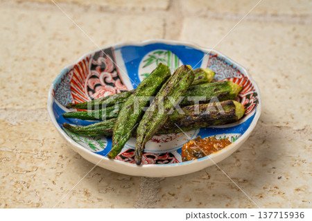 炭烤秋葵:居酒屋(日本酒吧)供應的一道香氣撲鼻的烤蔬菜菜餚。 炭烤秋葵:居酒屋(日本酒吧)供應的一道香氣撲鼻的烤蔬菜菜餚。 137715936