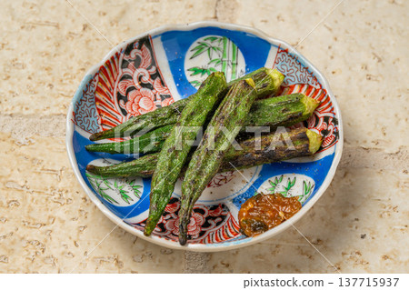 炭烤秋葵:居酒屋(日本酒吧)供應的一道香氣撲鼻的烤蔬菜菜餚。 炭烤秋葵:居酒屋(日本酒吧)供應的一道香氣撲鼻的烤蔬菜菜餚。 137715937