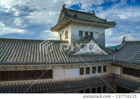 Himeji, Japan - Sep 24 2024, panoramic view from window of roofs and towers decorated with roof tiles in courtyard of Himeji Castle, White Heron Castle, at daytime with cloudy sky, Himeji, Japan 137716115