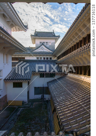 Himeji, Japan - Sep 24 2024, vertical, panoramic view from window of roofs and towers with roof tiles in courtyard of Himeji Castle, White Heron Castle, at daytime with cloudy sky, Himeji, Japan Himeji, Japan - Sep 24 2024, vertical, panoramic view from window of roofs and towers with roof tiles in courtyard of Himeji Castle, White Heron Castle, at daytime with cloudy sky, Himeji, Japan 137716118