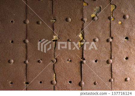 Himeji, Japan - Sep 24 2024, A close-up view of a metal surface consisting of old, rusty, partially destroyed iron sheets with rivets, inside Himeji Castle, White Heron Castle, Himeji, Japan 137716124