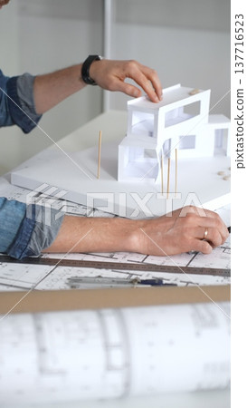 Architect creating building plans and innovative housing design with detailed blueprints. Developing contemporary residential projects 137716523