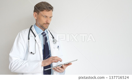 Confident doctor man wearing stethoscope and white coat, standing with crossed arms and gazing thoughtfully, representing medical professionalism and expertise. Medicine and health care Confident doctor man wearing stethoscope and white coat, standing with crossed arms and gazing thoughtfully, representing medical professionalism and expertise. Medicine and health care 137716524