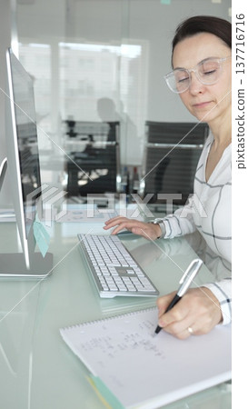 Woman analyst working on computer, analyzing business data with charts and graphs, marketing report on screen. Businesspeople concept Woman analyst working on computer, analyzing business data with charts and graphs, marketing report on screen. Businesspeople concept 137716716