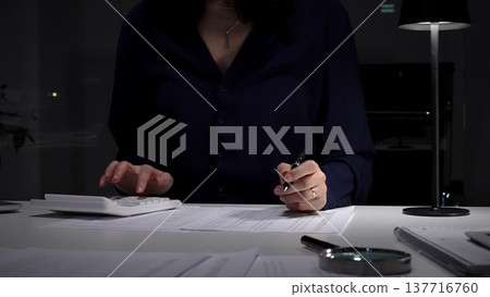 Financial audit and fraud detection using a magnifying glass, reviewing documents and calculating numbers. Audit and taxes in business Financial audit and fraud detection using a magnifying glass, reviewing documents and calculating numbers. Audit and taxes in business 137716760