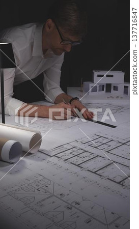 Architect working on blueprint with compass, developing engineering plans and creative building design. Concept of architecture and business in low key lighting Architect working on blueprint with compass, developing engineering plans and creative building design. Concept of architecture and business in low key lighting 137716847