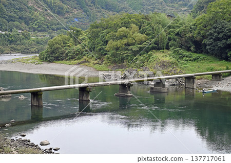 岩間潛水橋橫跨清澈的四萬十川河水,青山倒映在水面上。 岩間潛水橋橫跨清澈的四萬十川河水,青山倒映在水面上。 137717061