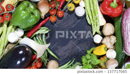 Fresh vegetables arranged on a dark surface for a recipe preparation scene in a kitchen during daytime Fresh vegetables arranged on a dark surface for a recipe preparation scene in a kitchen during daytime 137717085