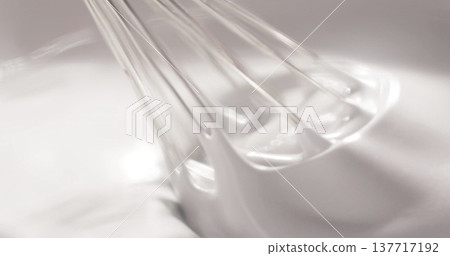 Whisk mixes egg whites in a clear bowl during a baking session in a kitchen on a sunny afternoon 137717192